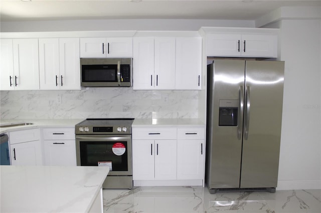 1109 N Obrien St, Tampa, FL 33607 - kitchen featuring appliances with stainless steel finishes, backsplash, light countertops, and white cabinets