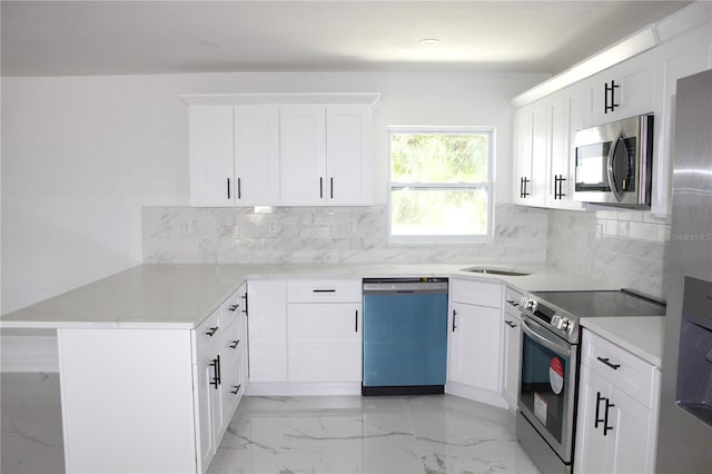 1109 N Obrien St, Tampa, FL 33607 - kitchen with stainless steel appliances, a peninsula, light marble finish flooring, light countertops, and recessed lighting
