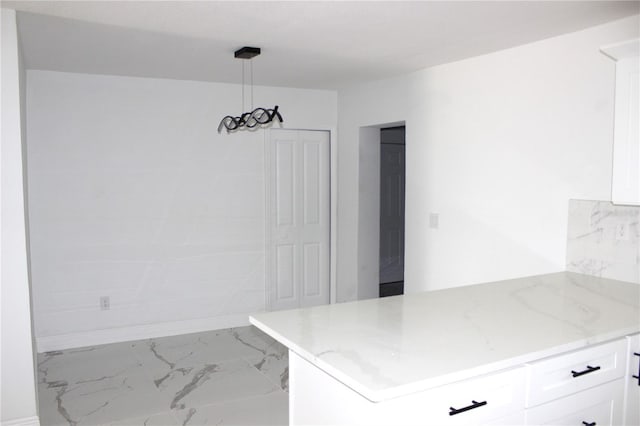 1109 N Obrien St, Tampa, FL 33607 - kitchen featuring white cabinets, light stone countertops, marble finish flooring, and hanging light fixtures