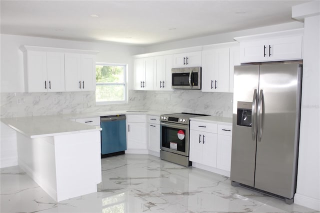 1109 N Obrien St, Tampa, FL 33607 - kitchen with appliances with stainless steel finishes, a peninsula, light marble finish floors, white cabinetry, and decorative backsplash