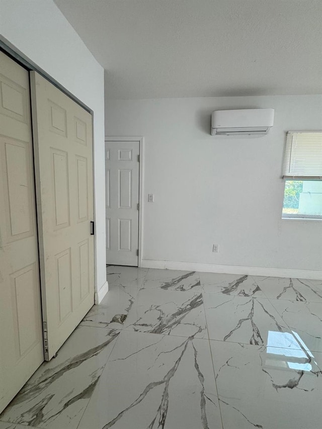 1109 N Obrien St, Tampa, FL 33607 - unfurnished room featuring a wall unit AC, baseboards, and light marble finish floors