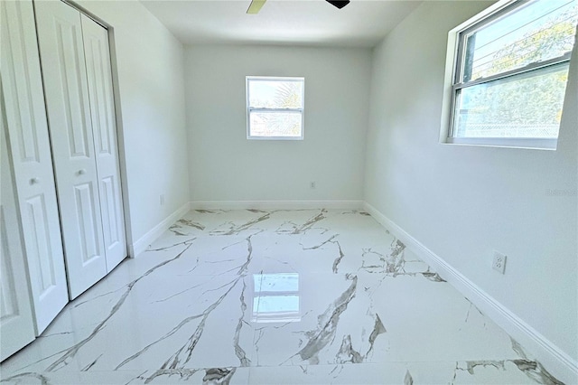 1109 N Obrien St, Tampa, FL 33607 - unfurnished bedroom with marble look tiles, baseboards, ceiling fan, and a closet