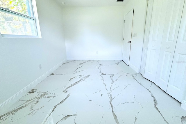 1109 N Obrien St, Tampa, FL 33607 - unfurnished bedroom with baseboards and marble look tile flooring