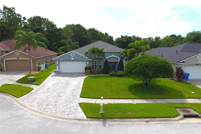 1842 Ridgelake Ct, Wesley Chapel, FL 33543 - view of front of home with an attached garage, a front yard, decorative driveway, and stucco siding