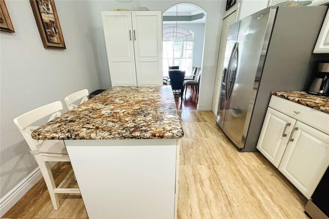 1842 Ridgelake Ct, Wesley Chapel, FL 33543 - kitchen featuring dark stone counters, a center island, white cabinetry, and light wood-style floors