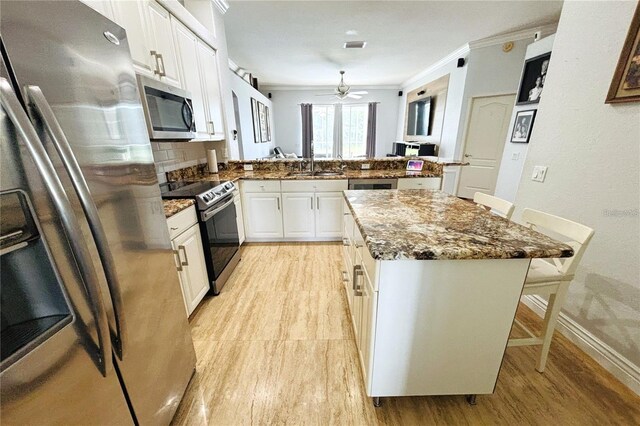1842 Ridgelake Ct, Wesley Chapel, FL 33543 - kitchen featuring stainless steel appliances, crown molding, a peninsula, a sink, and a breakfast bar area
