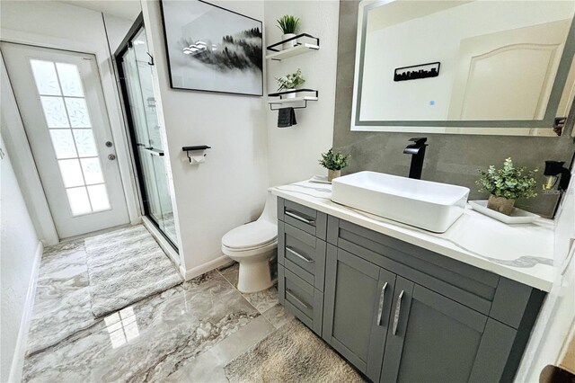 1842 Ridgelake Ct, Wesley Chapel, FL 33543 - bathroom featuring marble look tile flooring, toilet, vanity, a stall shower, and plenty of natural light