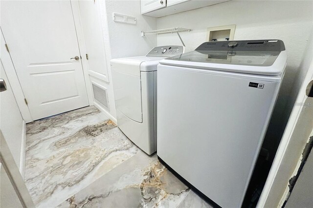 1842 Ridgelake Ct, Wesley Chapel, FL 33543 - laundry area featuring washing machine and clothes dryer, cabinet space, and light marble finish flooring