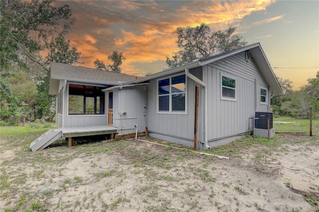 5290 Cyril Dr, Dade City, FL 33523 - view of front of home featuring board and batten siding, a wooden deck, and central AC unit