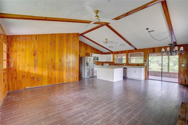 5290 Cyril Dr, Dade City, FL 33523 - unfurnished living room featuring wood walls, a ceiling fan, a chandelier, and dark wood-type flooring