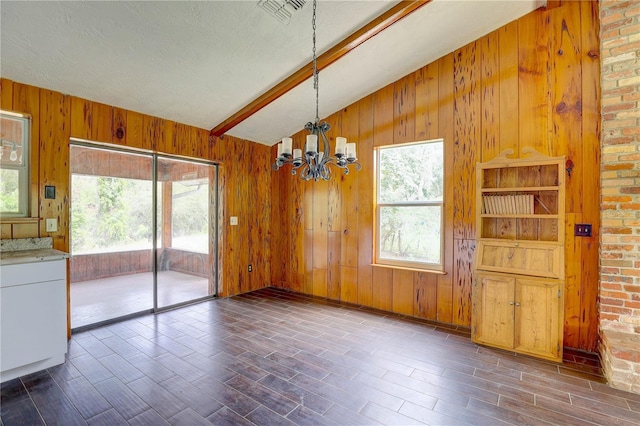 5290 Cyril Dr, Dade City, FL 33523 - unfurnished dining area featuring a chandelier, wood finished floors, healthy amount of natural light, and wooden walls