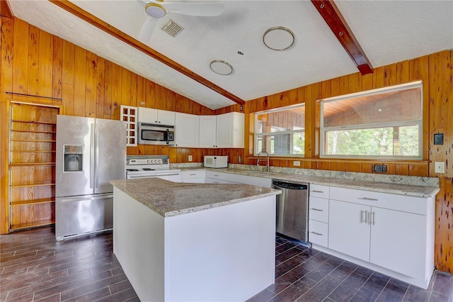 5290 Cyril Dr, Dade City, FL 33523 - kitchen featuring stainless steel appliances, dark wood-style flooring, wooden walls, a sink, and white cabinets
