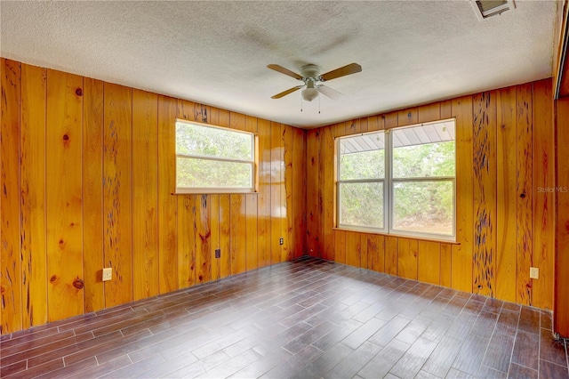 5290 Cyril Dr, Dade City, FL 33523 - spare room with a ceiling fan, a textured ceiling, wood walls, and wood finished floors
