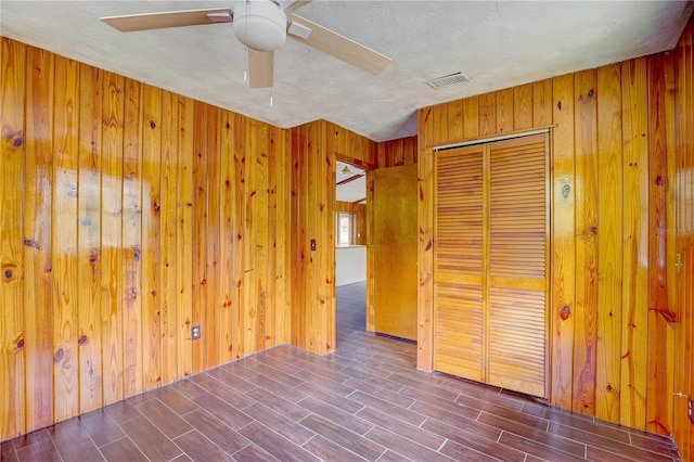 5290 Cyril Dr, Dade City, FL 33523 - unfurnished bedroom featuring wood walls, a closet, wood finished floors, and a ceiling fan