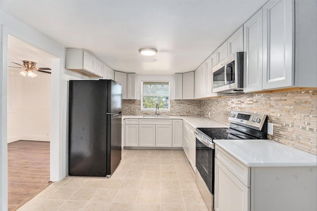 3008 E Wilder Ave, Tampa, FL 33610 - kitchen with stainless steel appliances, light countertops, decorative backsplash, and light tile patterned floors