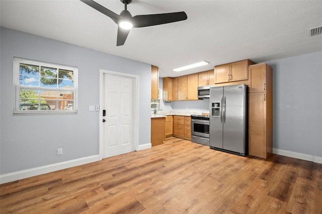 2809 Marconi St, Tampa, FL 33605 - kitchen with appliances with stainless steel finishes, light countertops, baseboards, light wood-type flooring, and a ceiling fan