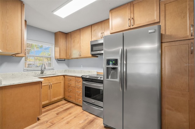 2809 Marconi St, Tampa, FL 33605 - kitchen with stainless steel appliances, a sink, light wood finished floors, and light stone counters