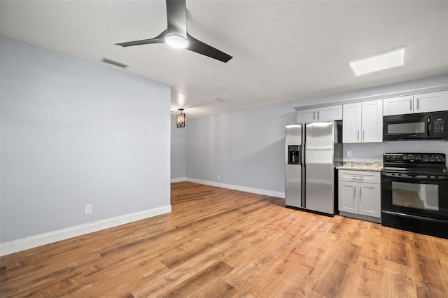 2809 Marconi St, Tampa, FL 33605 - kitchen with black appliances, light wood-style flooring, baseboards, and a ceiling fan