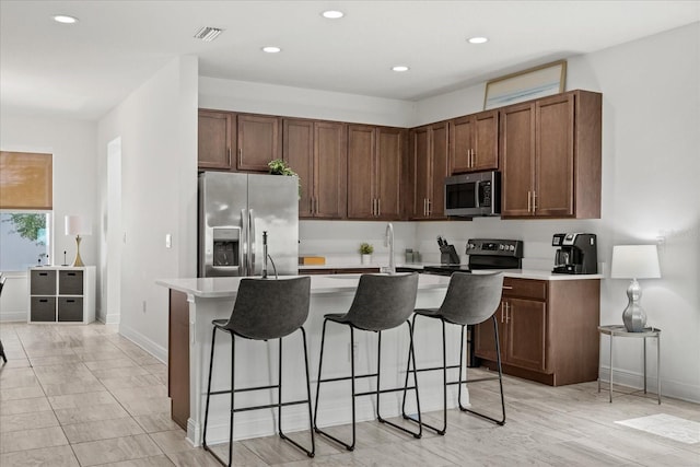 4206 W N B St Unit 1, Tampa, FL 33609 - kitchen with stainless steel appliances, light countertops, a breakfast bar, a center island with sink, and recessed lighting