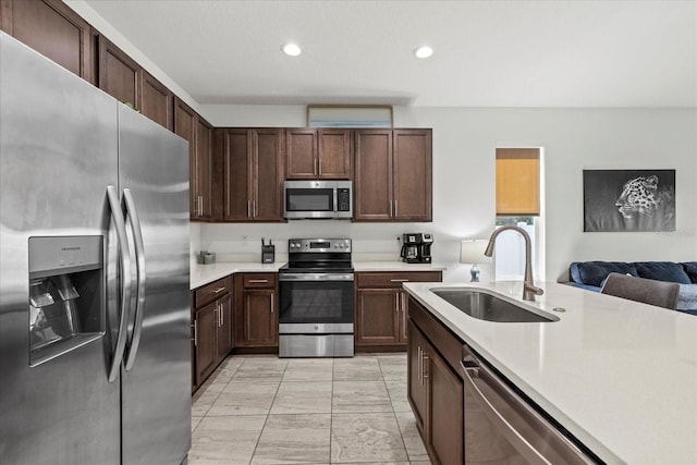 4206 W N B St Unit 1, Tampa, FL 33609 - kitchen featuring stainless steel appliances, light countertops, light marble finish floors, recessed lighting, and dark brown cabinets
