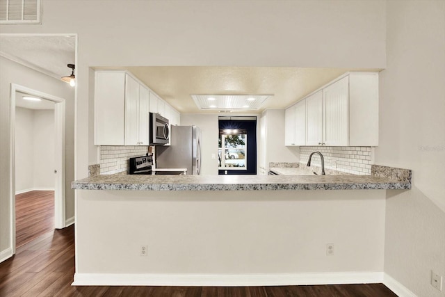 4342 Candler Ave, Spring Hill, FL 34609 - kitchen with stainless steel appliances, backsplash, dark wood-style floors, and recessed lighting