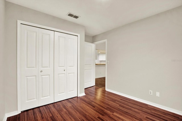 4342 Candler Ave, Spring Hill, FL 34609 - unfurnished bedroom featuring dark wood finished floors, baseboards, and a closet
