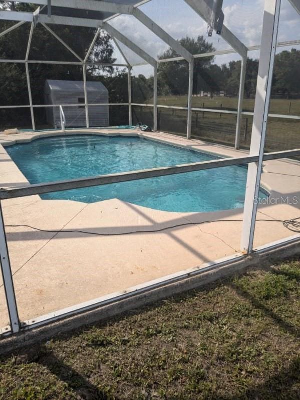 9761 Councilor Ln, North Fort Myers, FL 33917 - outdoor pool featuring a patio area and glass enclosure