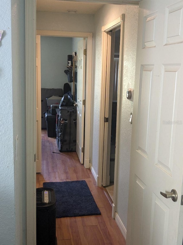 9761 Councilor Ln, North Fort Myers, FL 33917 - hallway with wood finished floors, a desk, a textured wall, and baseboards
