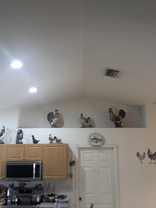 9761 Councilor Ln, North Fort Myers, FL 33917 - kitchen with stainless steel microwave, electric range, light countertops, and vaulted ceiling