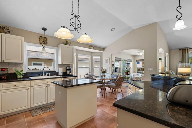 810 Erik Lake Rd, Brandon, FL 33510 - kitchen featuring a sink, a kitchen island, arched walkways, vaulted ceiling, and tasteful backsplash