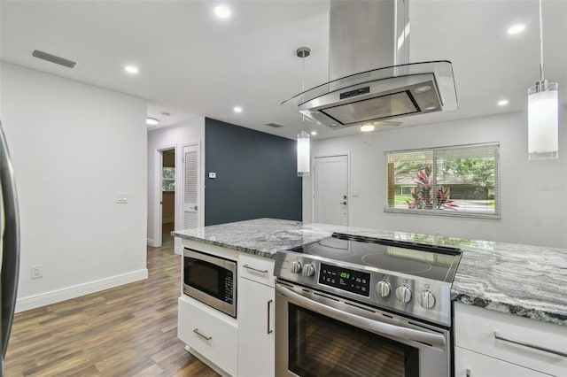 1311 W Perdiz St, Tampa, FL 33612 - kitchen featuring appliances with stainless steel finishes, range hood, white cabinetry, recessed lighting, and wood finished floors