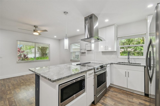 1311 W Perdiz St, Tampa, FL 33612 - kitchen featuring appliances with stainless steel finishes, island exhaust hood, a peninsula, plenty of natural light, and recessed lighting