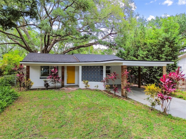 1311 W Perdiz St, Tampa, FL 33612 - view of front of house with concrete driveway, a front yard, and an attached carport