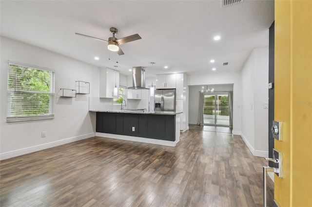 1311 W Perdiz St, Tampa, FL 33612 - kitchen with wall chimney exhaust hood, stainless steel refrigerator with ice dispenser, a peninsula, white cabinets, and dark wood-style floors