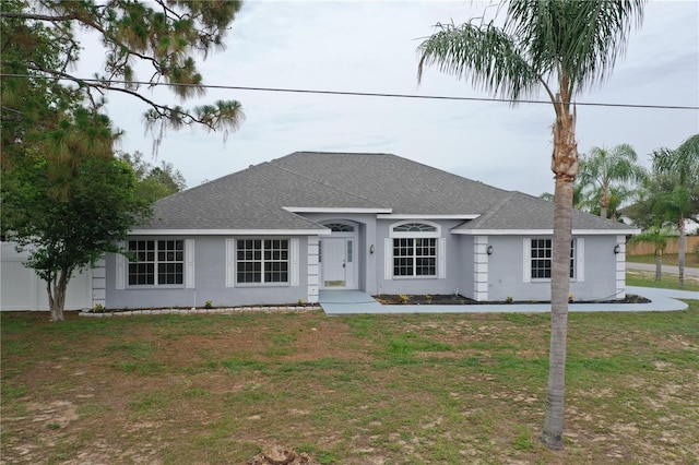 13551 Banner Rd, Spring Hill, FL 34609 - ranch-style home with roof with shingles, a front yard, and stucco siding