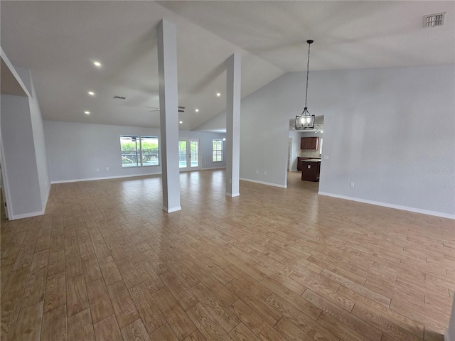 13551 Banner Rd, Spring Hill, FL 34609 - unfurnished living room featuring wood finished floors, lofted ceiling, baseboards, and a chandelier