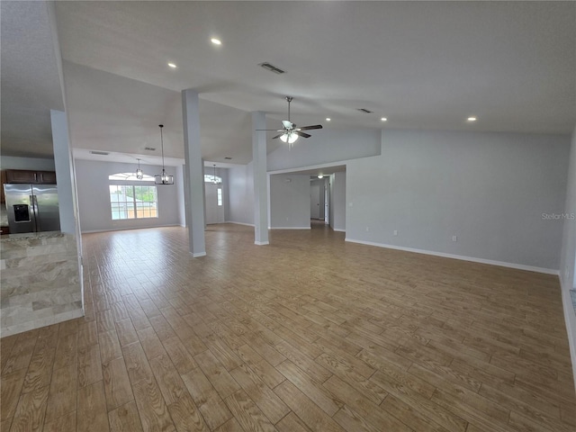 13551 Banner Rd, Spring Hill, FL 34609 - unfurnished living room with a ceiling fan, vaulted ceiling, light wood finished floors, a chandelier, and baseboards