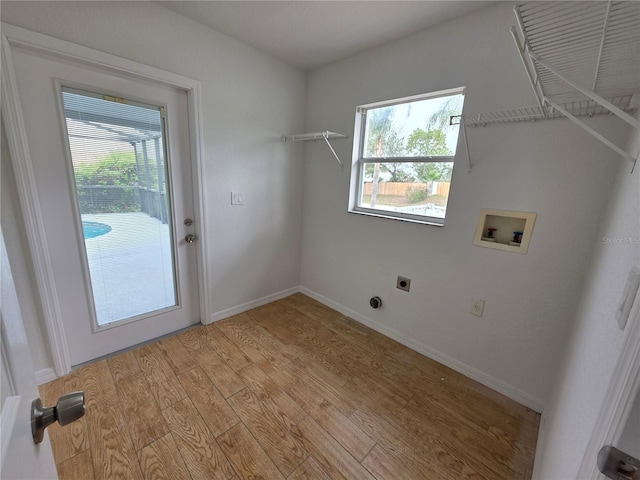 13551 Banner Rd, Spring Hill, FL 34609 - laundry area featuring washer hookup, electric dryer hookup, light wood-style floors, and baseboards