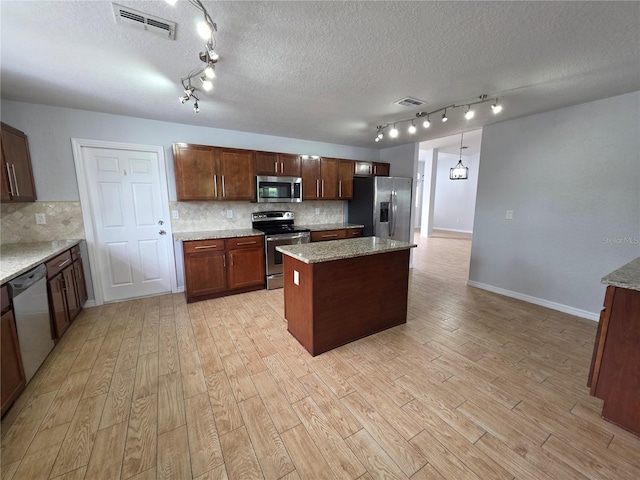 13551 Banner Rd, Spring Hill, FL 34609 - kitchen featuring stainless steel appliances, rail lighting, light wood-style flooring, tasteful backsplash, and a textured ceiling