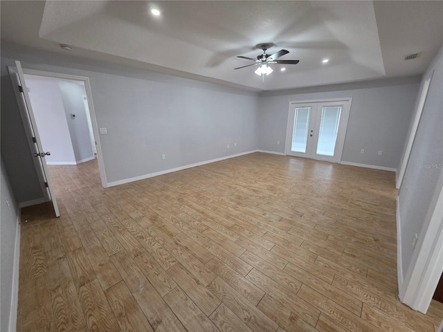 13551 Banner Rd, Spring Hill, FL 34609 - empty room featuring a raised ceiling, ceiling fan, light wood-style floors, baseboards, and recessed lighting