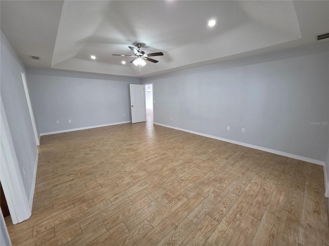 13551 Banner Rd, Spring Hill, FL 34609 - unfurnished room featuring a tray ceiling, wood finished floors, a ceiling fan, baseboards, and recessed lighting