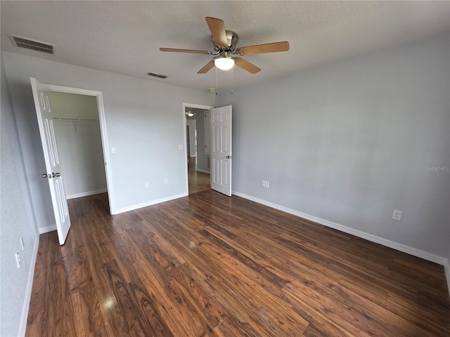 13551 Banner Rd, Spring Hill, FL 34609 - unfurnished bedroom with dark wood-type flooring, a walk in closet, baseboards, ceiling fan, and a closet