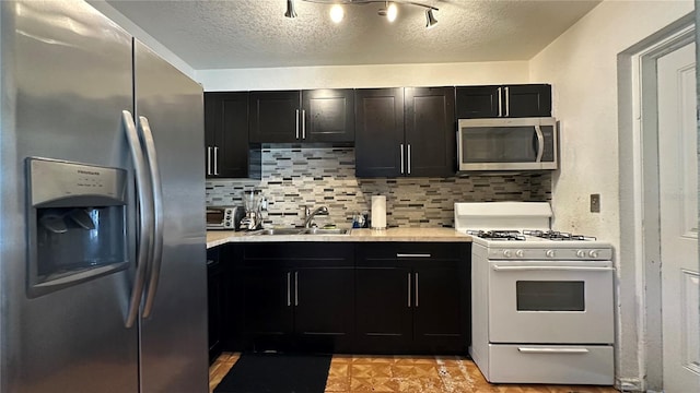 1701 NW 10th Ave, Fort Lauderdale, FL 33311 - kitchen with stainless steel appliances, a sink, light countertops, backsplash, and a textured ceiling