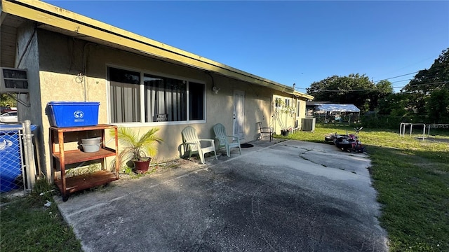 1701 NW 10th Ave, Fort Lauderdale, FL 33311 - view of side of home with a patio, stucco siding, and cooling unit