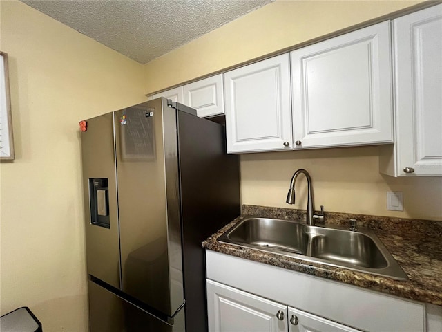 4215 E Bay Dr Unit 1707C, Clearwater, FL 33764 - kitchen with stainless steel refrigerator with ice dispenser, a sink, dark countertops, white cabinets, and a textured ceiling