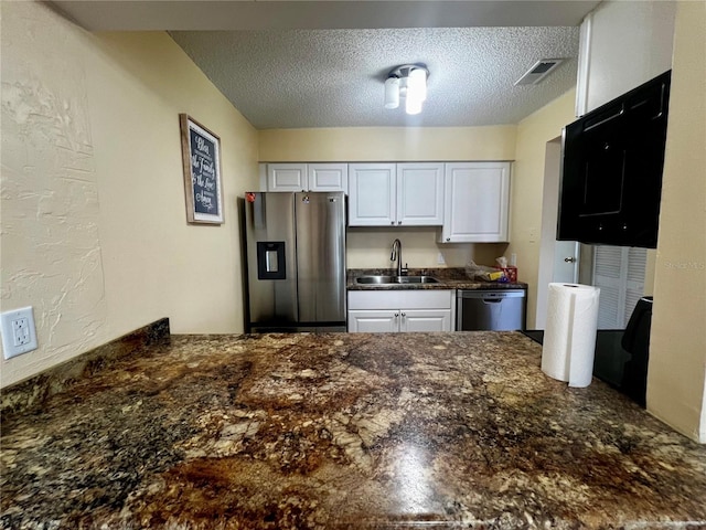 4215 E Bay Dr Unit 1707C, Clearwater, FL 33764 - kitchen featuring appliances with stainless steel finishes, a sink, a textured ceiling, a peninsula, and white cabinetry