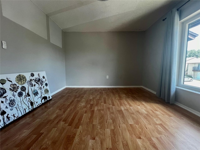 4215 E Bay Dr Unit 1707C, Clearwater, FL 33764 - bonus room with wood finished floors, vaulted ceiling, baseboards, and a textured ceiling