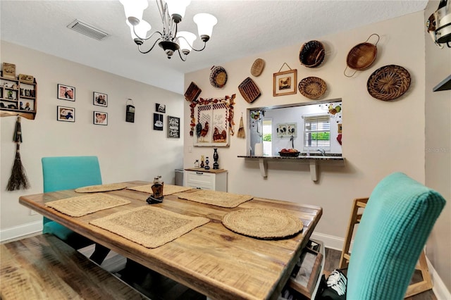 213 Draw Bridge Ln, Valrico, FL 33594 - dining room featuring a chandelier, baseboards, wood finished floors, and a textured ceiling