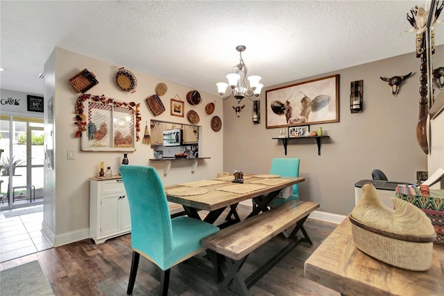 213 Draw Bridge Ln, Valrico, FL 33594 - dining space with a chandelier, dark wood-style flooring, a textured ceiling, and baseboards