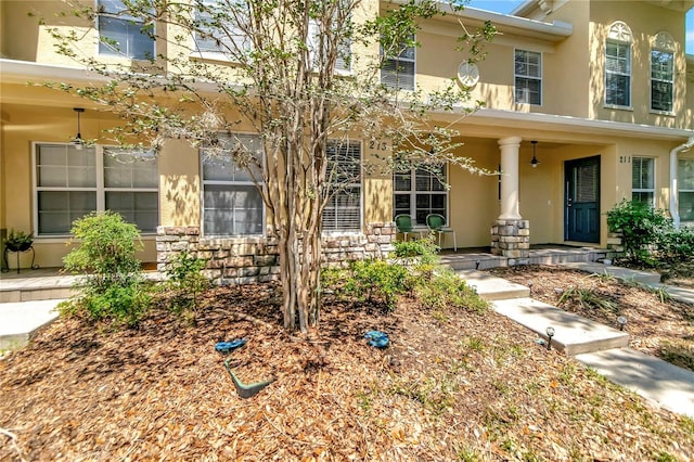 213 Draw Bridge Ln, Valrico, FL 33594 - view of front of home with stucco siding, a porch, and stone siding
